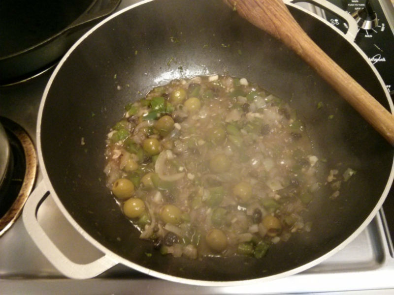 Add olives, raisins, capers, cilantro, garlic, wine, vinegar and continue saute